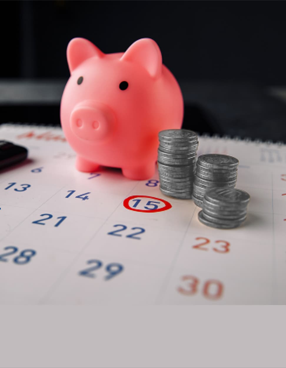Piggy bank and coins on a calendar